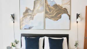 A neatly arranged bedroom with a bed, two bedside lamps, and a wall-mounted artwork. - Porthtowan Coastal Escape with minutes away from the Beach (Truro)