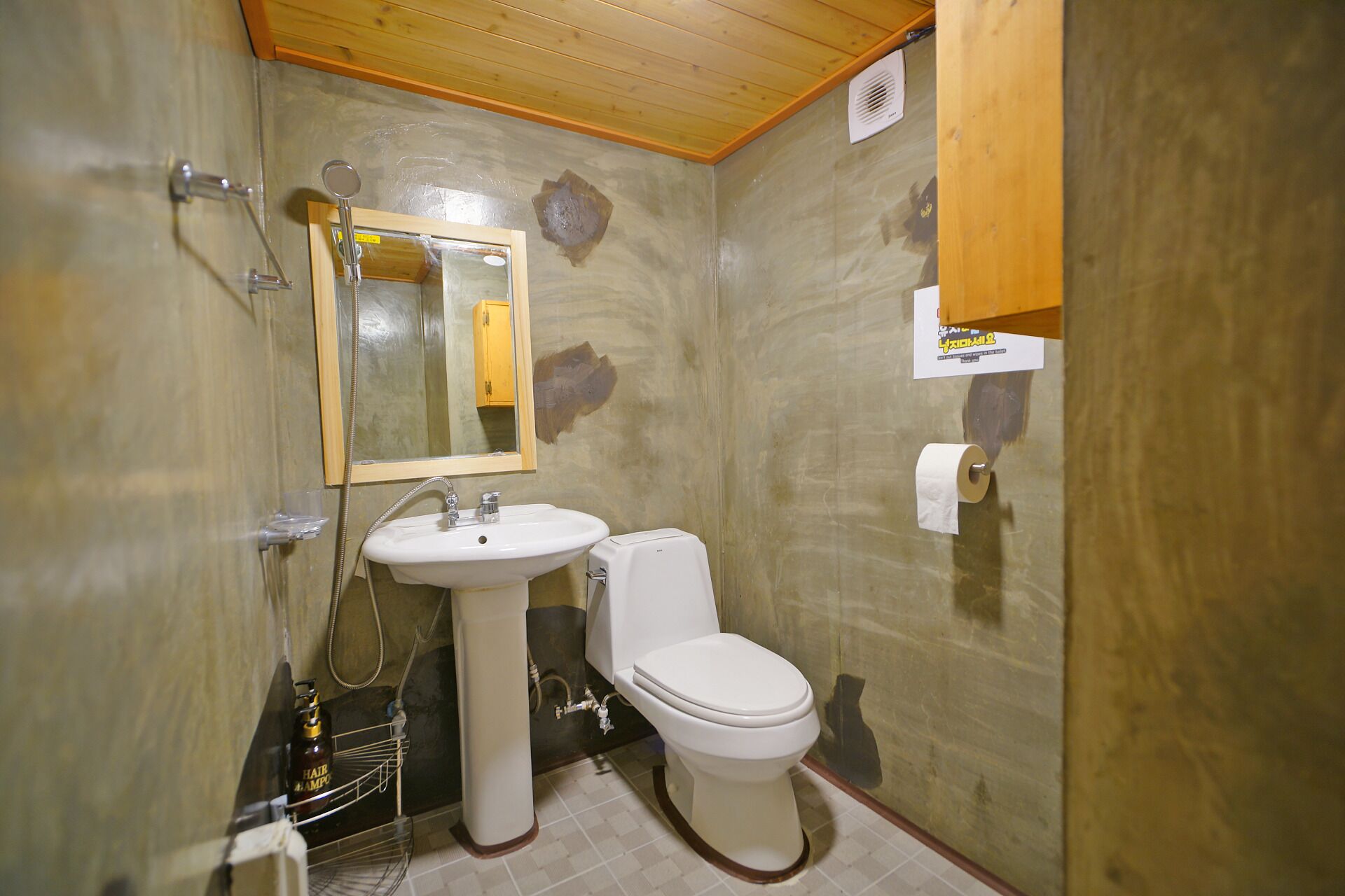 Un baño con lavamanos, inodoro y espejo.