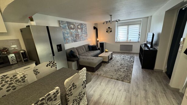 Ein kompakter Wohnbereich mit Sofa, Couchtisch und Essbereich.