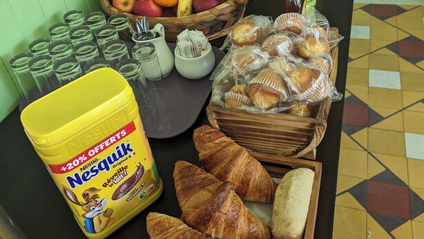 A breakfast buffet with various food items including bread, pastries, fruits, and beverages. - AUBERGE DES PINS (Aubenas)