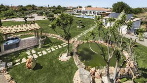 A well-maintained garden with a hot tub, a pool, and a gazebo.
