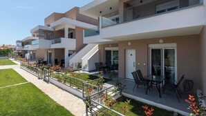 Un immeuble d’appartements moderne doté de balcons, d’un espace extérieur aménagé et d’un jardin bien entretenu.