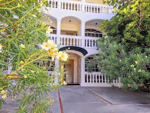 A two-story building with a white facade, balconies, and a central entrance. - Cozy Apartment in Gated Community Costambar, Puerto Plata (Puerto Plata)