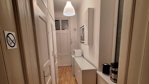 A narrow hallway with wooden flooring, white walls, and a white ceiling light. There is a door with a no-smoking sign on the left and a framed picture on the right. - KURZZEITMIETE (short time rent) from 1 month for 1-2 PERS., BEST LOCATION, near center (Wien)