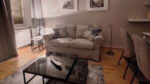A living room with a sofa, two framed pictures on the wall, a coffee table, and a floor lamp. - KURZZEITMIETE (short time rent) from 1 month for 1-2 PERS., BEST LOCATION, near center (Wien)