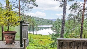 Puinen terassi, jolta avautuu näkymä puilla ympäröidylle järvelle.