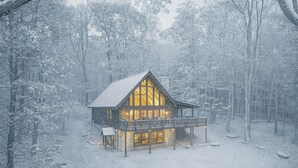 A cabin with a wooden exterior, a balcony, and a porch area.