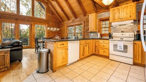 A spacious kitchen with wooden cabinets, a large island, and a stone accent wall.