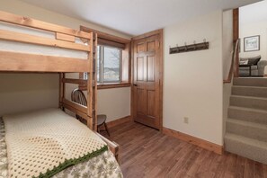 A room with a bunk bed, a wooden door, a window, a chair, and a staircase. - Luxe MTN Escape 15 min to Winter Park Base (Tabernash)