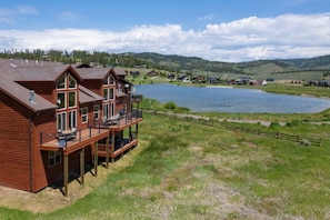 A wooden cabin with a balcony overlooking a lake and hills. - Luxe MTN Escape 15 min to Winter Park Base (Tabernash)