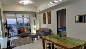 Ein modernes Wohnzimmer mit Essbereich, großen Fenstern und Blick auf die Stadt.