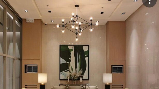 Eine moderne Lobby mit einer zentralen Sitzgruppe, einem großen abstrakten Gemälde und einem Chandelier.