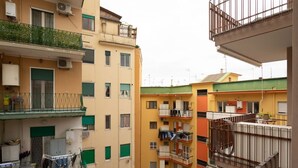 Un edificio residencial de varios pisos con balcones, unidades de aire acondicionado y ropa tendida.