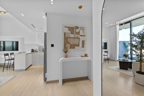 Une cuisine moderne dotée d’un îlot central, d’un coin repas avec des chaises et d’une grande fenêtre offrant une vue dégagée.