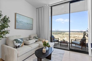 Un salon moderne avec un canapé, une table basse et un tableau.