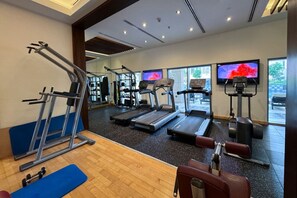 Et fitnesscenter med løbebånd, crosstrainere og vægtbænke.