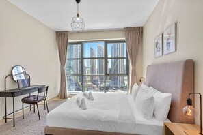 A hotel room with a large window, a bed, a desk, and a chair.