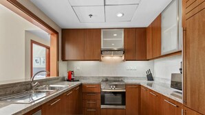 Eine moderne Küche mit Holzschränken, Edelstahlgeräten und einer Arbeitsplatte aus Granit.