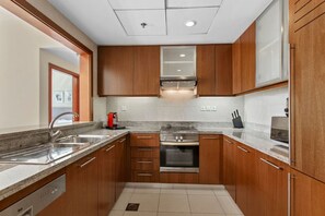 Una cocina moderna con armarios de madera, electrodomésticos de acero inoxidable y una encimera de granito.