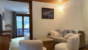 A cozy living room with a sofa, two armchairs, a wooden coffee table, and a painting on the wall. - Spacious T3 for 6 near slopes, comfortable, pets allowed (Les Orres)