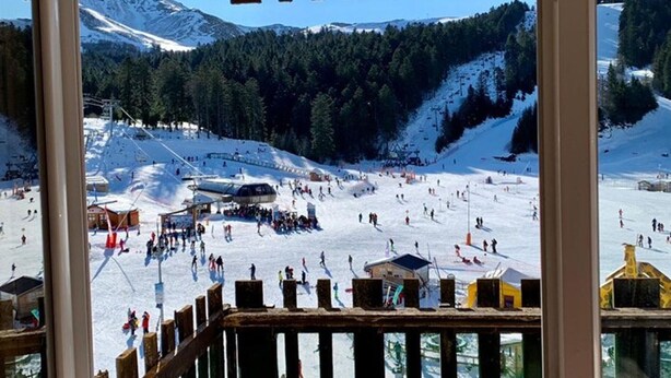 Ein Skigebiet mit verschneiter Landschaft, Seilbahnen und einem Bergpanorama.