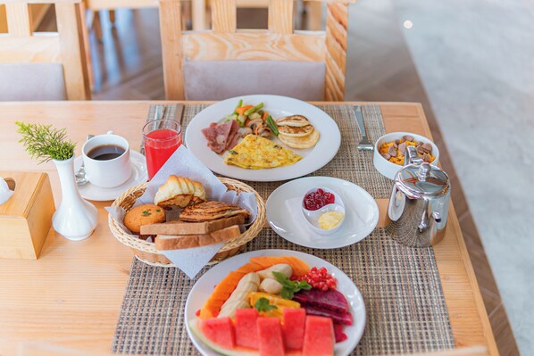 A breakfast table with various dishes including toast, eggs, and fruit.
