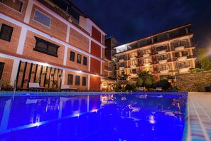A hotel with a swimming pool, multiple balconies, and a brick facade. - Temple Himalaya Hotel & Spa (Pokhara)