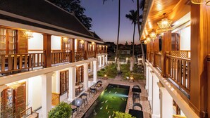 A hotel with a pool, outdoor seating, and wooden architecture. - Elegant Boutique Hotel Luangpraban (Luang Prabang)