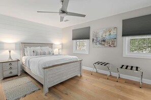 A bedroom with a bed, bedside tables, a ceiling fan, and a window with blinds. - Coastal Casa-Old Village-5 mins to Beach (Mount Pleasant)