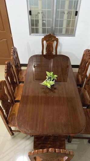 Enjoy meals in this elegant dining room with a wooden table and six chairs, accompanied by a potted plant.