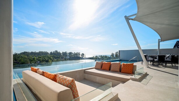 A rooftop terrace with a pool, outdoor seating, and a view of the surrounding landscape. - Angsana Oceanview Residences by Banyan Living (Choeng Thale)