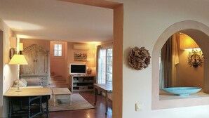 Ein großzügiger Wohnbereich mit Fernseher, Sitzgelegenheiten und Wandkunst.