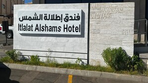 A sign for Itlalat Alshams Hotel with Arabic text and English translation. - sun view hotel (Tabuk)