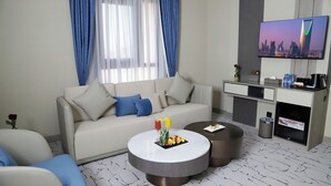 A modern living room with a sofa, coffee table, and TV. - sun view hotel (Tabuk)