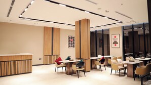 A modern cafe with wooden accents, multiple tables, and chairs arranged for seating. - sun view hotel (Tabuk)