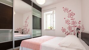 Ein Schlafzimmer mit Bett, Fenster und Spiegel.