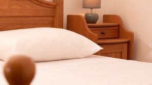 A neatly made bed with a wooden headboard and a bedside table with a lamp. - Cozy Icici Apartment With Sea View (Opatija)