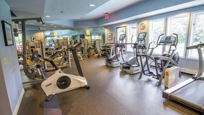 Een fitnessruimte met loopbanden, elliptische trainers en gewichten.