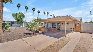 A modern house with a covered patio, palm trees, and a cactus in the yard. - Splash Pad - Toys - Pets OK - 8 Min to Oldtown (Scottsdale)