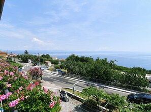 A coastal road with a clear view of the sea, surrounded by greenery and residential buildings. - Scenic Retreat Rooms and Family Apartment (Moscenicka Draga)