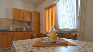 A dining table with a floral tablecloth, a pitcher of juice, and a tray with glasses. - Scenic Retreat Rooms and Family Apartment (Moscenicka Draga)