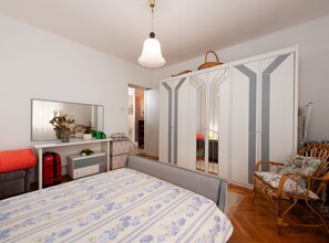 A bedroom with a bed, a desk, a chair, a wardrobe, and a mirror. - Elegant Lovran Apartment With Large Outdoor Area (Lovran)