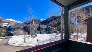 A view from a window overlooking a snow-covered landscape with houses and mountains. - Telluride Lodge, Your mountain gateaway with amazing service and very affordable (Telluride)