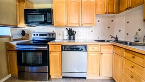 A kitchen with wooden cabinets, a microwave, an oven, a dishwasher, and a sink. - Telluride Lodge, Your mountain gateaway with amazing service and very affordable (Telluride)