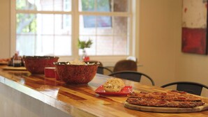Un comptoir de cuisine avec une pizza, un biscuit et un bol.