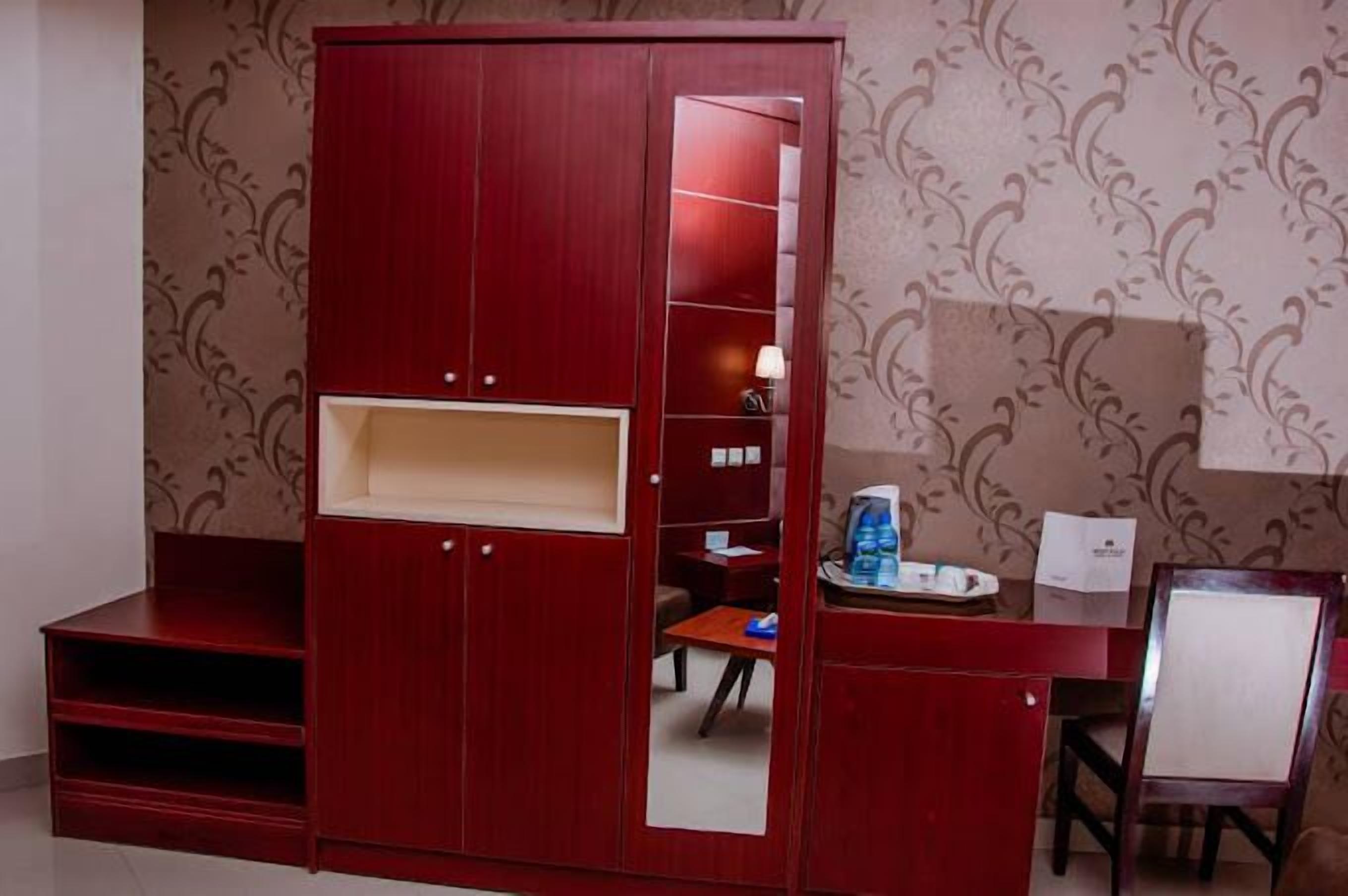 Une pièce avec une armoire rouge, un bureau et une chaise.