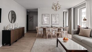 A modern living room with a dining area, a sofa, a coffee table, and a chandelier. - Stylish Waterfront Apt Stockholm (Stockholms län)
