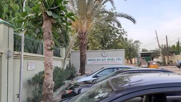 Un espace de stationnement avec un panneau indiquant le Green Palace Hotel Ltd.