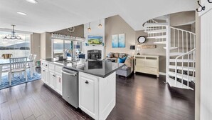 A spacious kitchen with a large island, white cabinetry, and a view of the outdoors. - Loft Condo with Stunning Lake Views (Moneta)