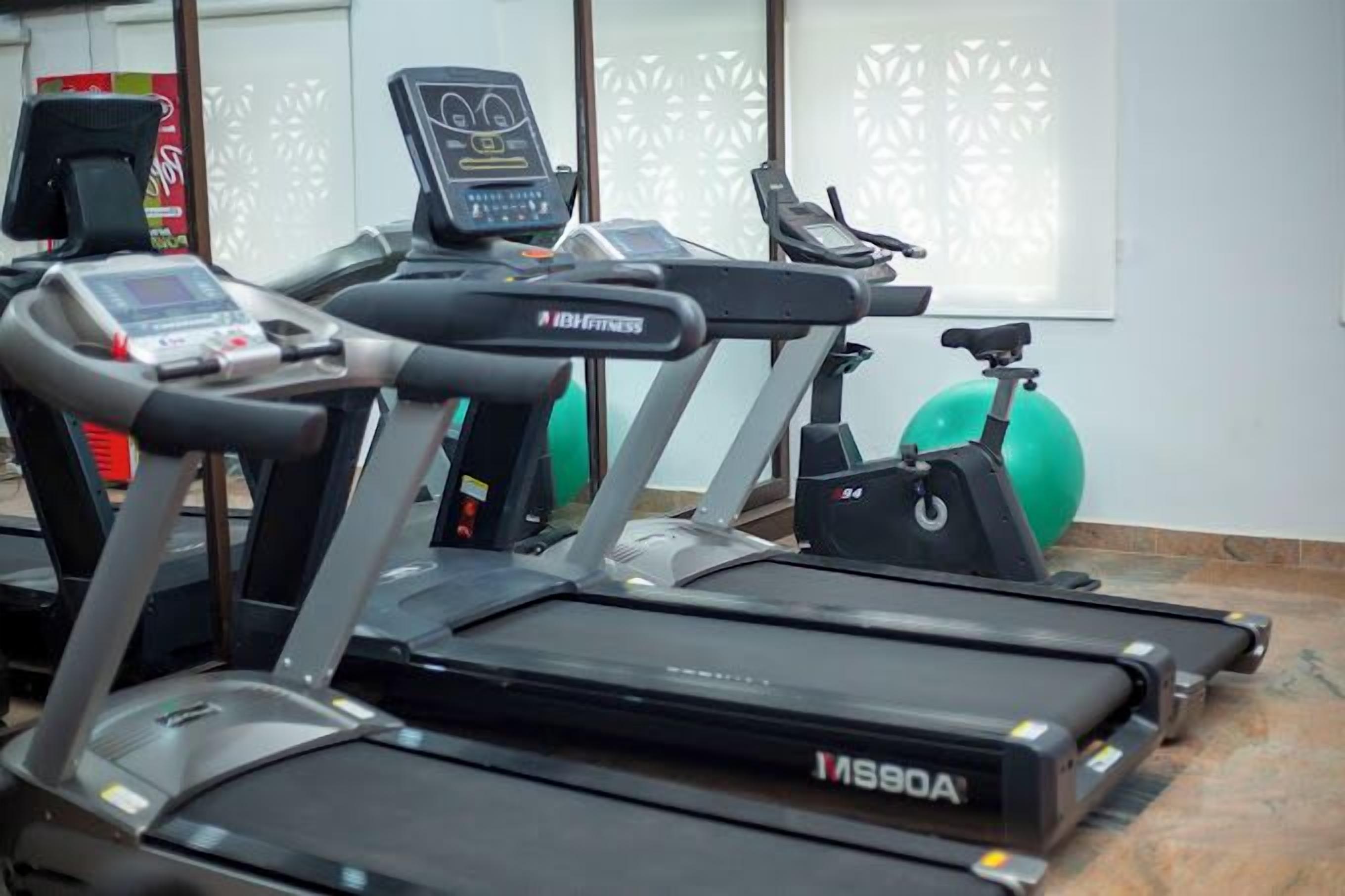 A gym with treadmills, an elliptical, and exercise balls.